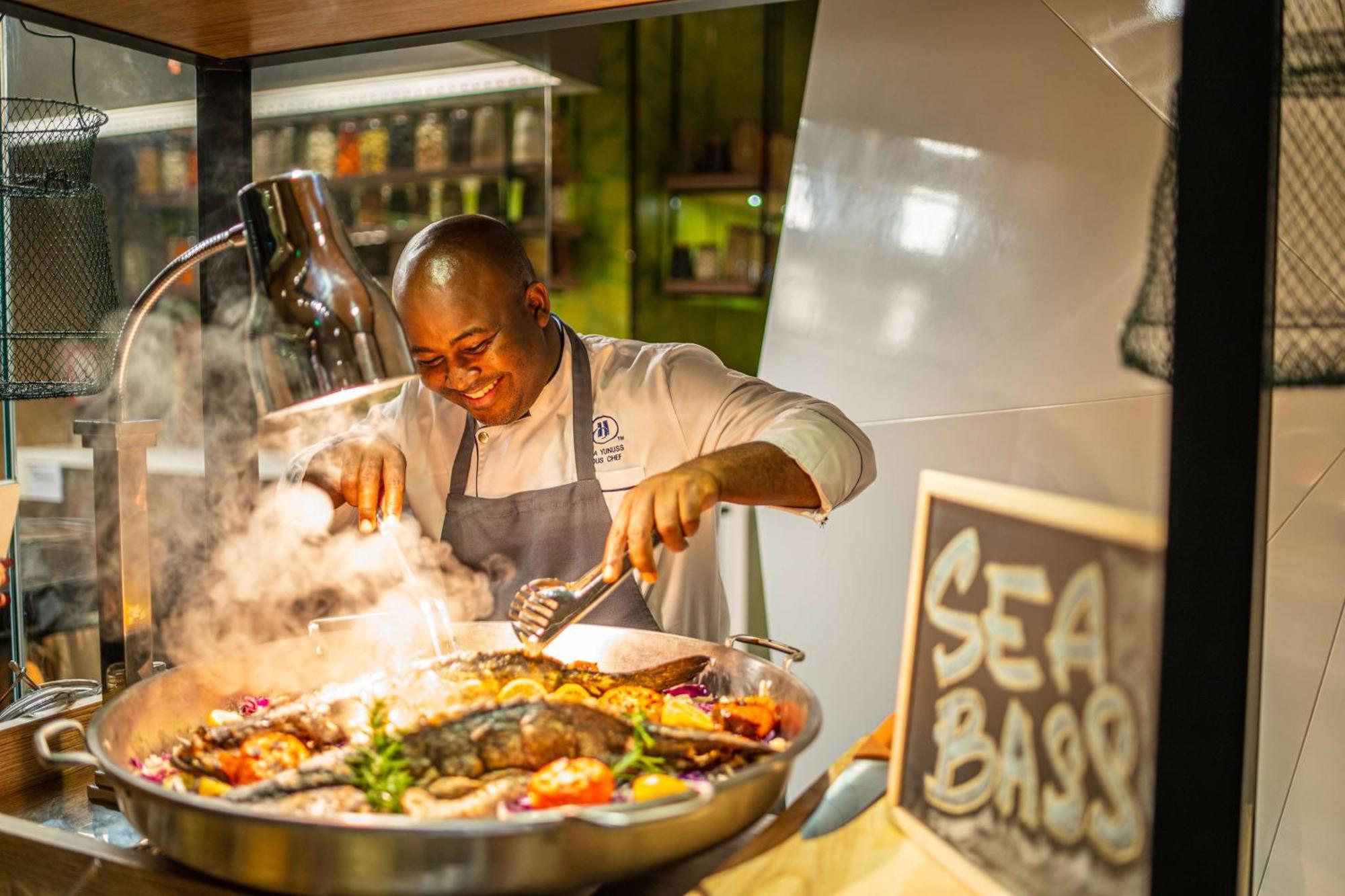 Hilton Bahrain Hotel Manama Exterior foto Chef preparing food at the Sea Bass restaurant